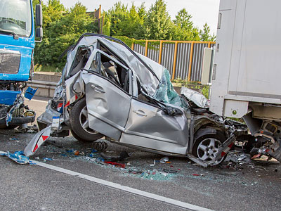 Ein schwer beschädigtes Auto nach einem Unfall mit einem Lastwagen.